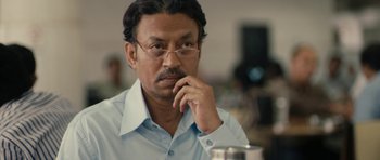 Movie still from “The Lunchbox” (2013), directed by Ritesh Batra – A person wearing glasses and a blue shirt; Close Up shot, Over the shoulder angle