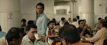 Movie still from “The Lunchbox” (2013), directed by Ritesh Batra – A group of people sitting at a table with drinks; Medium shot, Over the shoulder angle