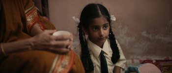 Movie still from “The Lunchbox” (2013), directed by Ritesh Batra – A young girl in a school uniform is holding a cup; Close Up shot, Over the shoulder angle