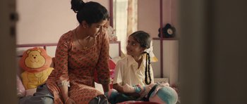 Movie still from “The Lunchbox” (2013), directed by Ritesh Batra – A woman and a girl sitting on a bed talking; Medium shot, Over the shoulder angle