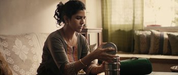 Movie still from “The Lunchbox” (2013), directed by Ritesh Batra – A woman is putting something in a spice container; Medium shot, Low angle