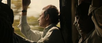 Movie still from “The Lunchbox” (2013), directed by Ritesh Batra – A man sitting on a train looking out the window; Close Up shot, Low angle