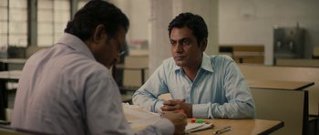 Movie still from “The Lunchbox” (2013), directed by Ritesh Batra – Two men sitting at a table talking to each other; Medium shot, Over the shoulder angle