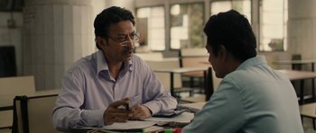 Movie still from “The Lunchbox” (2013), directed by Ritesh Batra – A man sitting in front of another man at a table; Medium shot, Over the shoulder angle