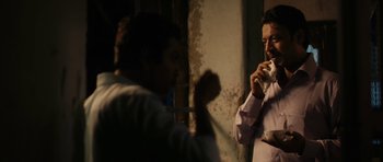 Movie still from “The Lunchbox” (2013), directed by Ritesh Batra – Two men are standing in a room and one of them is holding a cup; Medium shot, Low angle