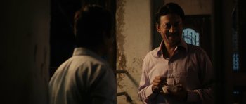 Movie still from “The Lunchbox” (2013), directed by Ritesh Batra – Two men are talking and laughing in a room; Medium shot, Over the shoulder angle