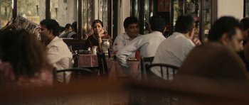 Movie still from “The Lunchbox” (2013), directed by Ritesh Batra – A group of people sitting at a table in a restaurant; Medium shot, Over the shoulder angle