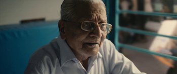 Movie still from “The Lunchbox” (2013), directed by Ritesh Batra – An older man wearing glasses and a white shirt; Close Up shot, Low angle