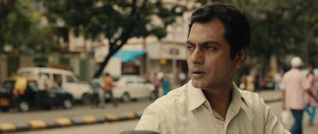 Movie still from “The Lunchbox” (2013), directed by Ritesh Batra – A person wearing a white shirt near a street; Close Up shot, Low angle