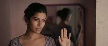 Movie still from “The Lunchbox” (2013), directed by Ritesh Batra – A woman with her hand up in the air in front of a mirror; Close Up shot, Low angle