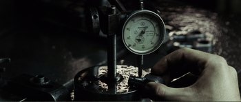 Movie still from “The Machinist” (2004), directed by Brad Anderson – A person is holding a tool in their hand; Extreme Close Up shot, Low angle