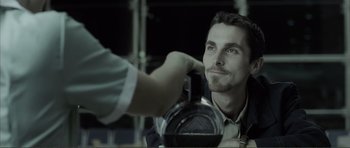 Movie still from “The Machinist” (2004), directed by Brad Anderson – A man is taking a picture of another man with a camera; Close Up shot, High angle