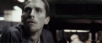 Movie still from “The Machinist” (2004), directed by Brad Anderson – A person looking at the camera; Close Up shot, Low angle