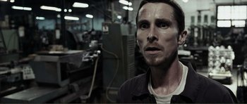 Movie still from “The Machinist” (2004), directed by Brad Anderson – A person in a factory; Close Up shot, Low angle