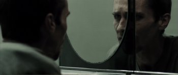 Movie still from “The Machinist” (2004), directed by Brad Anderson – A man looking at himself in the mirror; Extreme Close Up shot, Over the shoulder angle