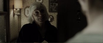 Movie still from “The Machinist” (2004), directed by Brad Anderson – An older woman with white hair looking into a mirror; Close Up shot, Over the shoulder angle