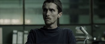Movie still from “The Machinist” (2004), directed by Brad Anderson – A person wearing a black shirt; Close Up shot, Over the shoulder angle