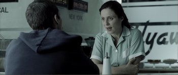 Movie still from “The Machinist” (2004), directed by Brad Anderson – A woman sitting in front of a man at a table; Close Up shot, Over the shoulder angle