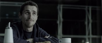 Movie still from “The Machinist” (2004), directed by Brad Anderson – A person sitting at a table; Close Up shot, Over the shoulder angle
