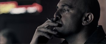 Movie still from “The Machinist” (2004), directed by Brad Anderson – A person smoking a cigarette; Close Up shot, Low angle