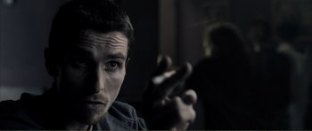 Movie still from “The Machinist” (2004), directed by Brad Anderson – A person holding something in his hand; Close Up shot, Over the shoulder angle