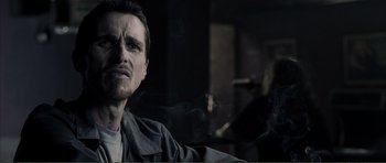 Movie still from “The Machinist” (2004), directed by Brad Anderson – A person with a cigarette in his mouth; Close Up shot, Over the shoulder angle