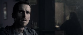 Movie still from “The Machinist” (2004), directed by Brad Anderson – A person sitting in a chair; Close Up shot, Over the shoulder angle