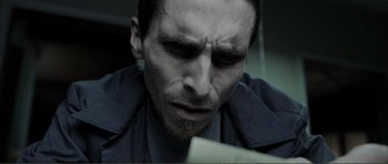 Movie still from “The Machinist” (2004), directed by Brad Anderson – A person looking at a paper; Close Up shot, Low angle