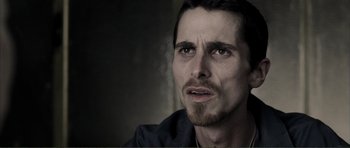 Movie still from “The Machinist” (2004), directed by Brad Anderson – A person with a beard; Close Up shot, Over the shoulder angle