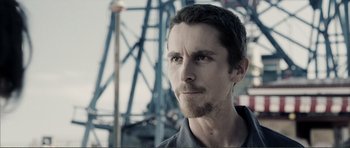 Movie still from “The Machinist” (2004), directed by Brad Anderson – A person with a beard; Close Up shot, Over the shoulder angle