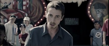 Movie still from “The Machinist” (2004), directed by Brad Anderson – A person wearing a button up shirt; Close Up shot, Over the shoulder angle