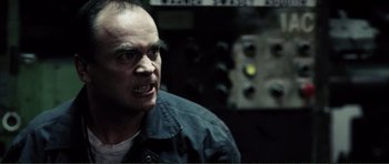 Movie still from “The Machinist” (2004), directed by Brad Anderson – A person in a dark room; Close Up shot, Low angle