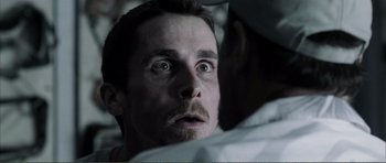 Movie still from “The Machinist” (2004), directed by Brad Anderson – A person looking at the camera; Close Up shot, Low angle