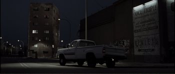 Movie still from “The Machinist” (2004), directed by Brad Anderson – A white truck parked on the side of the road at night; Extreme Wide shot, Low angle