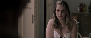 Movie still from “The Machinist” (2004), directed by Brad Anderson – A woman in a white top is standing in a room; Close Up shot, Over the shoulder angle