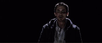 Movie still from “The Machinist” (2004), directed by Brad Anderson – A man with a black shirt and a black jacket; Close Up shot, Low angle