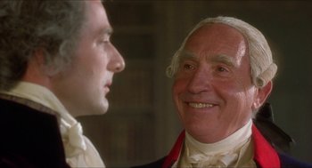 Movie still from “The Madness of King George” (1994), directed by Nicholas Hytner – A man in a suit and tie next to another man in a suit and tie; Close Up shot, Over the shoulder angle