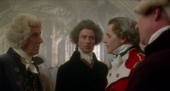Movie still from “The Madness of King George” (1994), directed by Nicholas Hytner – Three men are standing together in a room; Medium shot, Over the shoulder angle