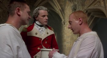 Movie still from “The Madness of King George” (1994), directed by Nicholas Hytner – A man in a red coat and two other men in a white shirt; Medium shot, Over the shoulder angle
