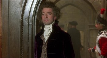 Movie still from “The Madness of King George” (1994), directed by Nicholas Hytner – A man in a purple jacket standing in front of a mirror; Medium shot, Low angle