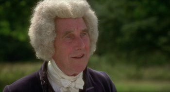 Movie still from “The Madness of King George” (1994), directed by Nicholas Hytner – An older man with a white wig is smiling for the camera; Close Up shot, Over the shoulder angle