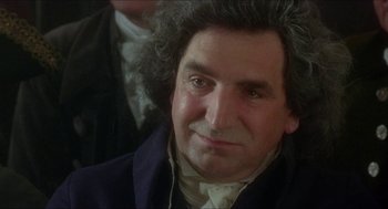 Movie still from “The Madness of King George” (1994), directed by Nicholas Hytner – A person wearing a suit and a wig; Close Up shot, Over the shoulder angle