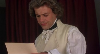 Movie still from “The Madness of King George” (1994), directed by Nicholas Hytner – A man wearing a white vest and a black bow tie; Close Up shot, Over the shoulder angle