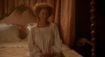 Movie still from “The Madness of King George” (1994), directed by Nicholas Hytner – A woman sitting on top of a bed wearing a white dress; Medium shot, High angle