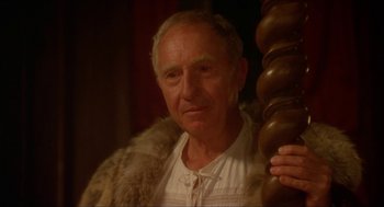 Movie still from “The Madness of King George” (1994), directed by Nicholas Hytner – An older man wearing a fur coat standing next to a wooden pole; Close Up shot, Over the shoulder angle