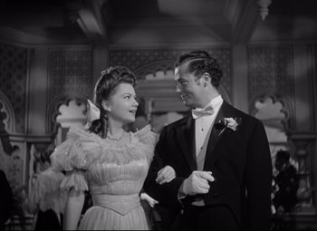 Movie still from “The Magnificent Ambersons” (1942), directed by Robert Wise – A man and a woman in formal wear standing next to each other; Medium shot, Low angle