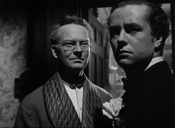 Movie still from “The Magnificent Ambersons” (1942), directed by Robert Wise – A man and a woman standing next to each other in front of a building; Close Up shot, Low angle