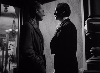 Movie still from “The Magnificent Ambersons” (1942), directed by Robert Wise – A couple of men standing next to each other; Medium shot, Over the shoulder angle