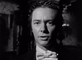 Movie still from “The Magnificent Ambersons” (1942), directed by Robert Wise – Black and white photograph of a man wearing a suit and bow tie; Close Up shot, Low angle