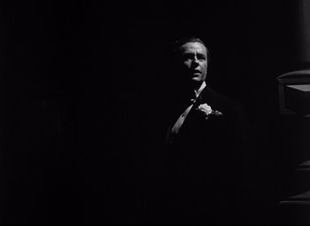 Movie still from “The Magnificent Ambersons” (1942), directed by Robert Wise – Black and white photograph of a man in a suit and tie; Close Up shot, Low angle